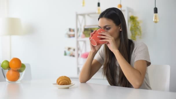 昼食を持っている女性、クロワッサンでコーヒーを飲む、甘いものから歯痛を感じる — ストック動画