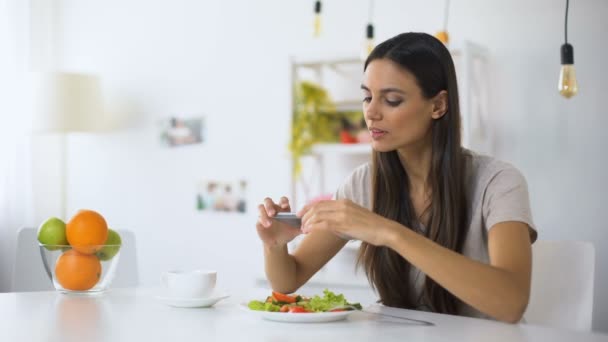 Jovem blogueiro de comida fazendo fotos de salada no telefone, postando em redes sociais — Vídeo de Stock