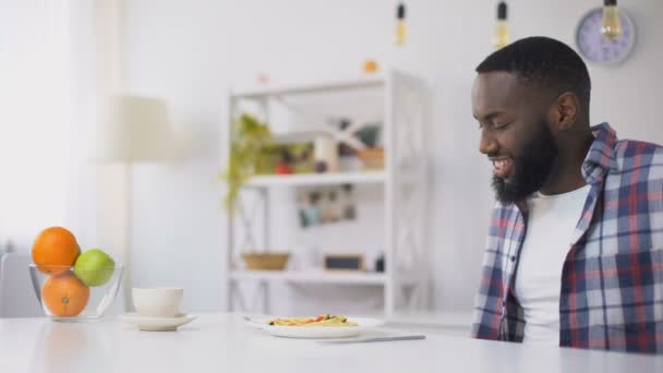 Hombre afroamericano comiendo espaguetis estropeados en el almuerzo, enfermedad estomacal, náuseas — Vídeos de Stock