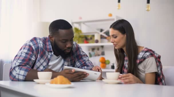 Famille mixte défilement sur tablette PC pendant le petit déjeuner, achats en ligne — Video