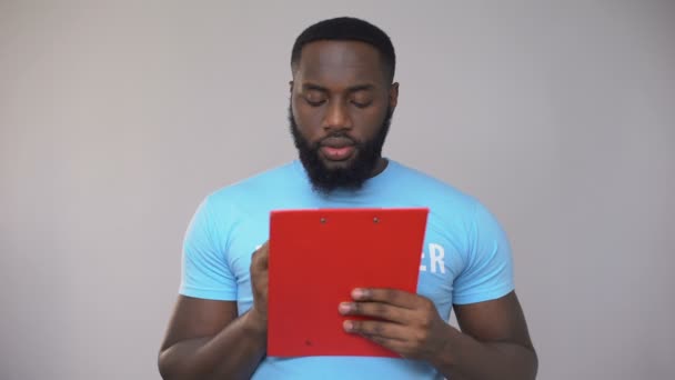 Black male volunteer filling data in registration form, festival organization — Stock Video