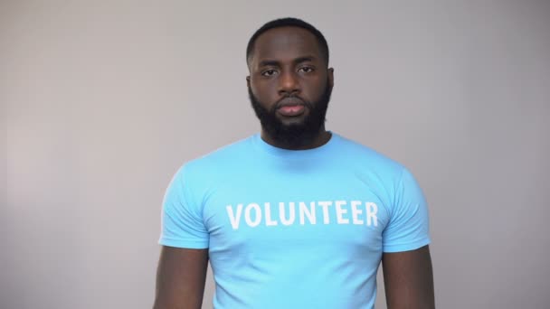 Afrikanisch-amerikanischer Freiwilliger zeigt rotes Band in die Kamera, hiv / aids-Symbol — Stockvideo