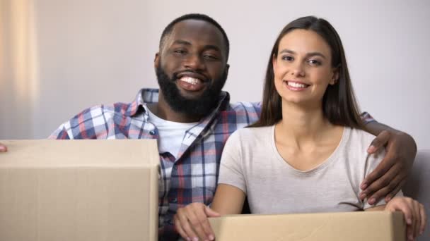 Happy mixed-race couple holding carton boxes, ready to move in new apartment — Stock Video