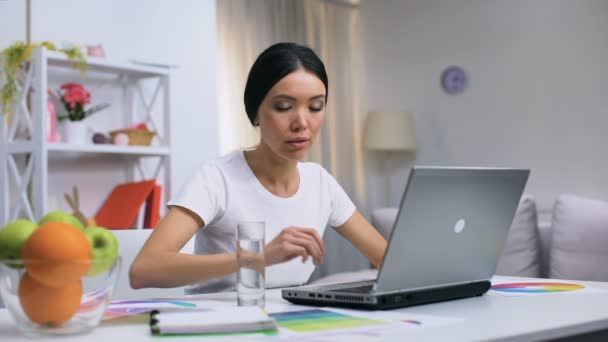 Evde laptop çalışan genç kadın, serbest tasarım projesi, kendi kendine istihdam — Stok video