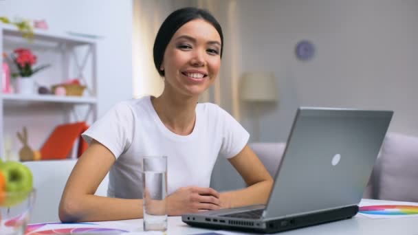 Gelukkig vrouwelijke freelancer glimlachen op de camera zitten thuis tafel, moderne baan — Stockvideo