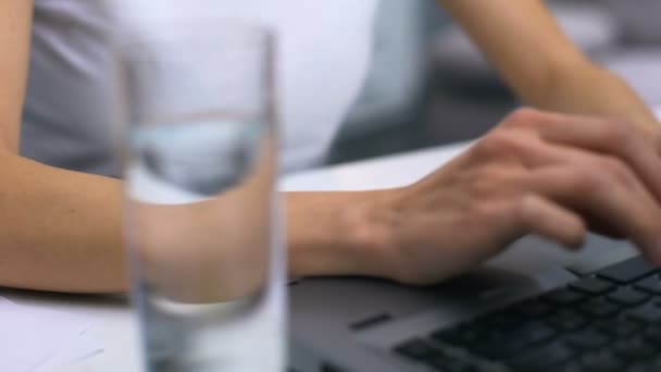 Mulher digitando teclado laptop, blogueiro trabalhando no projeto, vidro de água na mesa — Vídeo de Stock