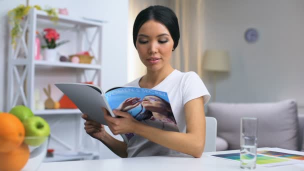 Mulher bonita leitura revista sentado à mesa, lazer em casa, fim de semana relaxar — Vídeo de Stock