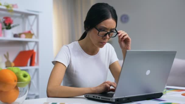超负荷工作的女性自由职业者摘下眼镜, 在笔记本电脑上工作, 加班 — 图库视频影像