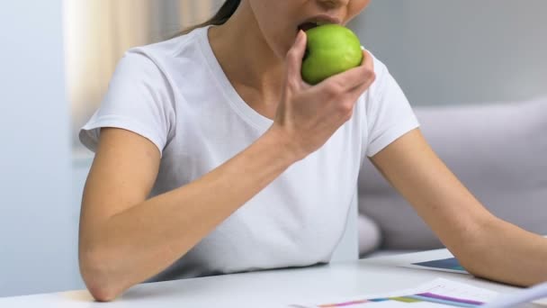 Kadın Freelancer grafik bakarak, elma ısırma ve ağrı hissi, taşır — Stok video