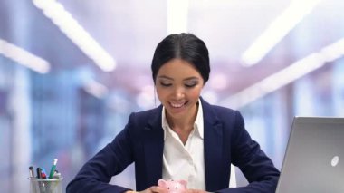 Neşeli Bayan piggybank sallayarak ve gülümseyen, gelecek için karlı yatırım