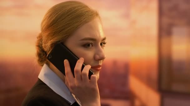Flirty gerente femenino hablando por teléfono, conversación personal en el lugar de trabajo — Vídeos de Stock