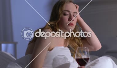 Geceleri yatakta şarap içen yalnız kadın, alkol bağımlılığı, depresyon