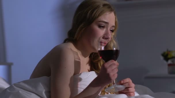 Joven llorando bebiendo vino en la cama, amor perdido, romper con el novio — Vídeo de stock