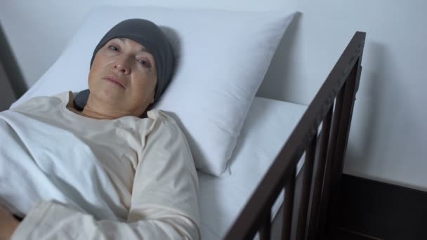 Hopeless female patient suffering cancer lying in sickbed and looking at camera — Stock Video