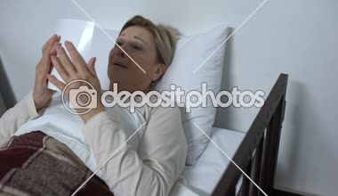 Hastane yatağında yatan umutsuz hasta kadın, Aile fotoğrafına bakıyor ve ağlıyor.