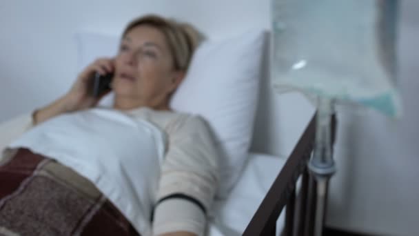 Gyenge hölgy beteg beszélő telefon és elalszik a sickbed közelében drop Counter — Stock videók
