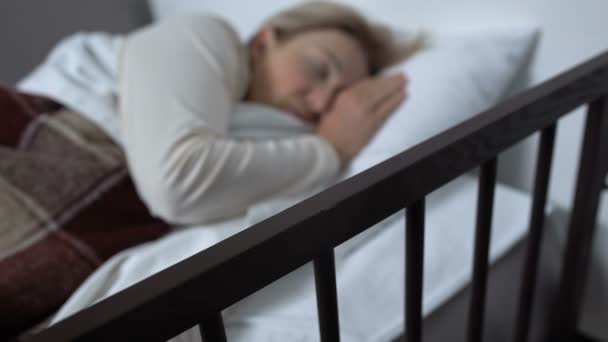 Зріла жінка лежить в лікарняному ліжку, раптом прокидається після кошмару, терапія — стокове відео