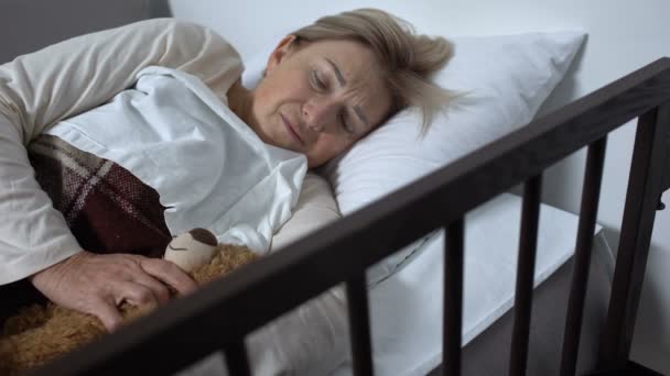 Mulher fraca deitada na cama doente no hospital abraçando brinquedo-urso, esperança de recuperação — Vídeo de Stock