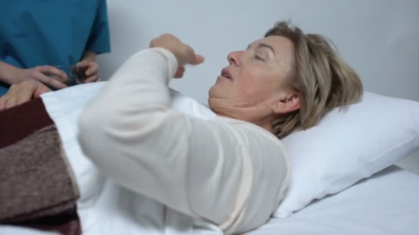 Enfermera dando dosis de antibióticos al paciente femenino después de la operación, hospital — Vídeo de stock