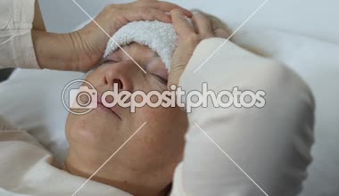 Hasta yaşlı Bayan alnında ıslak havlu ile kafa tutarak, ateş muzdarip