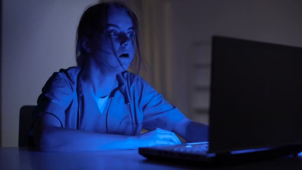 Infirmière de service se réveillant et tapant sur ordinateur portable, se dépêchant de respecter la date limite au travail — Video