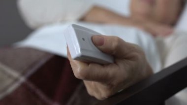 Yaşlı kadın neredeyse yatakta nefes, çağrı düğmesi itmek, tıbbi yardım ihtiyacı