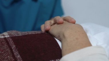 Yatakta yatan yaşlı kadın hasta gönüllü tutarak, bakım ve destek