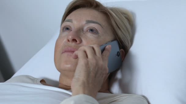 Hrubá sestřička bere starší pacientku do telefonu, nedodržuje nemocné lidi — Stock video