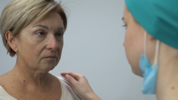 Médico informando velho paciente diagnóstico ruim, abraçando e apoiando choro senhora — Vídeo de Stock