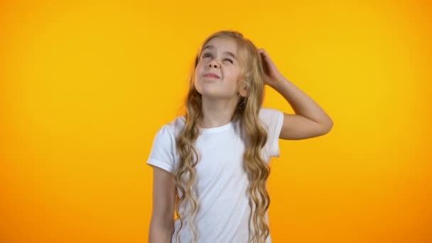 Komisch verwirrtes Schulmädchen, das sich am Kopf kratzt und mit den Schultern zuckt, Ideenlosigkeit — Stockvideo