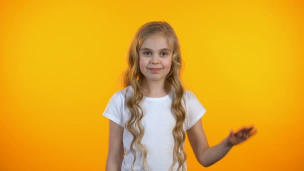 Vacker liten flicka viftande Hej, leende vänlig mot kameran, lycklig barn dom — Stockvideo