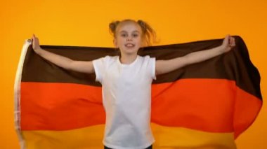 Sevimli preteen kız atlama ile Alman bayrağı tezahürat için favori spor takım