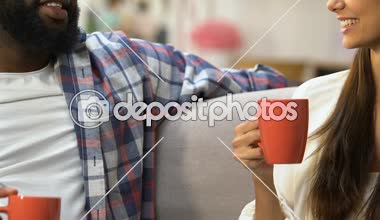 Afro-Amerikan adam ve beyaz kız çay içme ve kanepede oturan sohbet