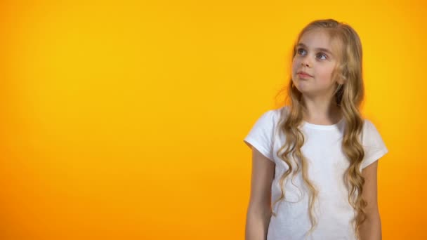 Menina bonita no fundo laranja cruzando as mãos no peito, modelo de anúncio — Vídeo de Stock
