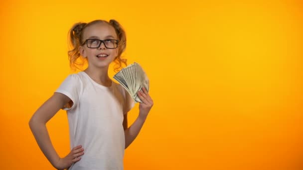 Забавная девушка, раздувающая из себя кучу долларов, первый доход, выигрыш в лотерею — стоковое видео