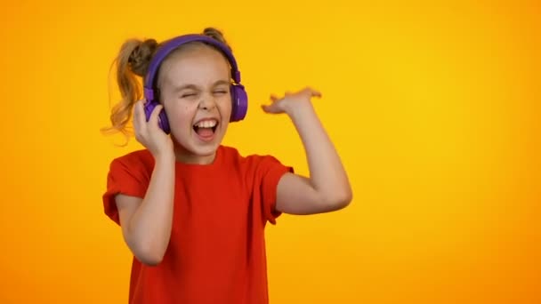 Bedårande flicka lyssnar på musik i hörlurar och dans, favorit låt, dröm — Stockvideo