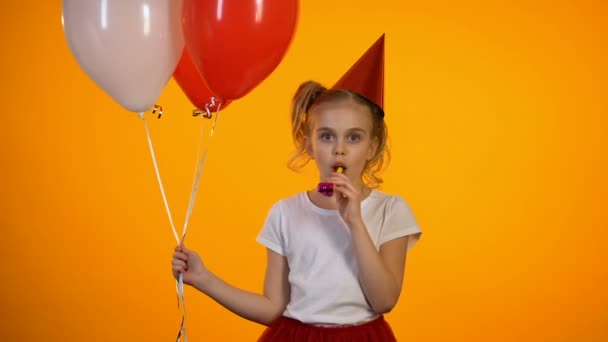 Niedliches Mädchen mit Party-Gebläse hält Luftballons und feiert Geburtstag, glücklich — Stockvideo