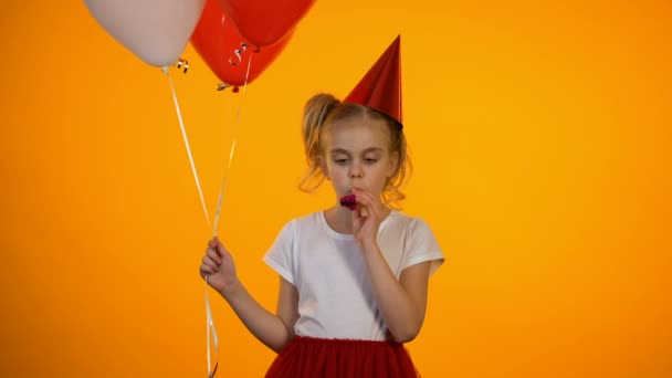 Molesto chica soplando cuerno de fiesta y celebración de globos, celebrando cumpleaños solo — Vídeos de Stock