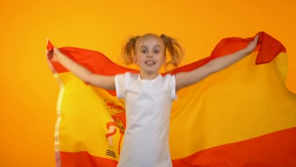 Buena chica saltando con bandera española animando al equipo de fútbol favorito, ventilador — Vídeo de stock