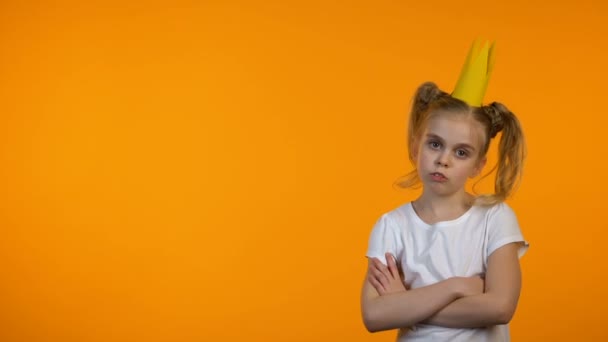 Vicces lány papír korona átkelés kezét a mellkason és a frowning, szemtelen gyerek — Stock videók