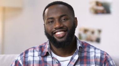 Gülümseyen African Amerikan adam düz Temizleme için hazır, temizlik ürünleri tutarak