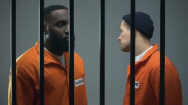 Hapis hücresinde çatışma eşiğinde endişeli Afro-Amerikan ve Avrupalı mahkumlar