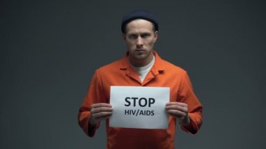 Hapsedilmiş adam stop HIV AIDS hücre, cinsel yolla bulaşan hastalık işareti tutarak