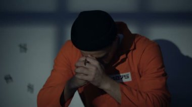 Avrupa hapsedilmiş Erkek Gümüş haç tutuyor ve hücre hissi suçlu dua