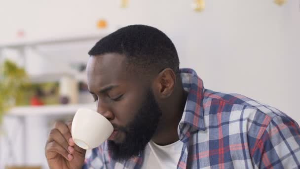 Zwarte man begint te hoesten en slaan zichzelf in de borst, man verslikte zich op thee — Stockvideo