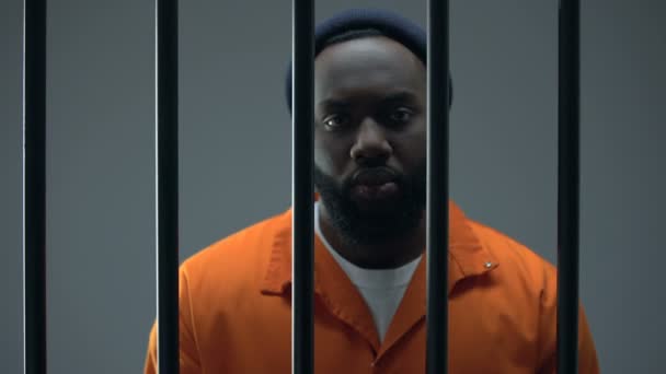 Несчастный чернокожий заключенный в наручниках, невинный мужчина ждет правосудия — стоковое видео