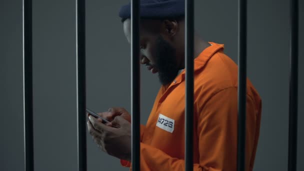 Αφροαμερικανός κρατούμενος που χρησιμοποιεί τηλέφωνο στο κελί, διαφθορά στις φυλακές, ποτοαπαγόρευση. — Αρχείο Βίντεο