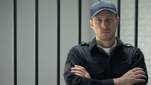 Säker fängelse väktare ser till kameran står nära cell, yrke — Stockvideo