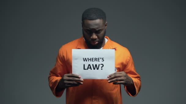 Afro-Amerikan mahkum Holding nerede hücre kanun işareti, yanlış suçlanan kişi — Stok video