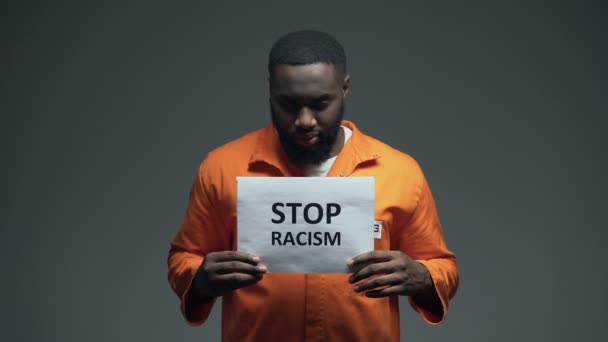 Zwarte gevangene Holding stop racisme teken, psychologische mishandeling, slechte behandeling — Stockvideo